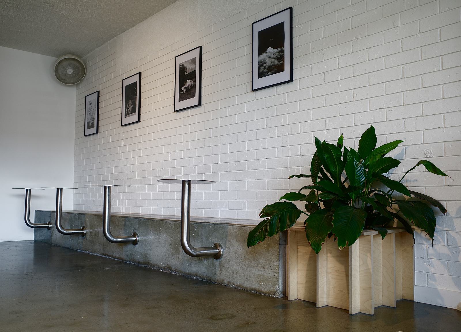 Stainless steel tables along the concrete bench under framed film prints