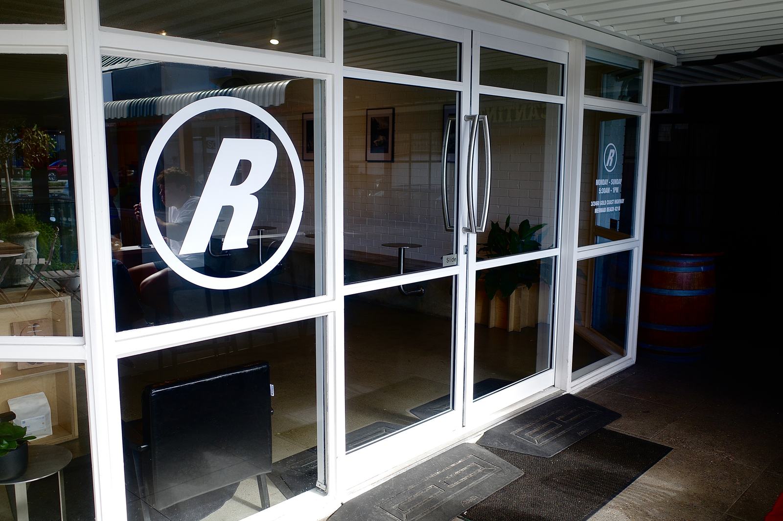 The Relaxed Espresso entrance at dusk — glass doors with the big R roundel decal