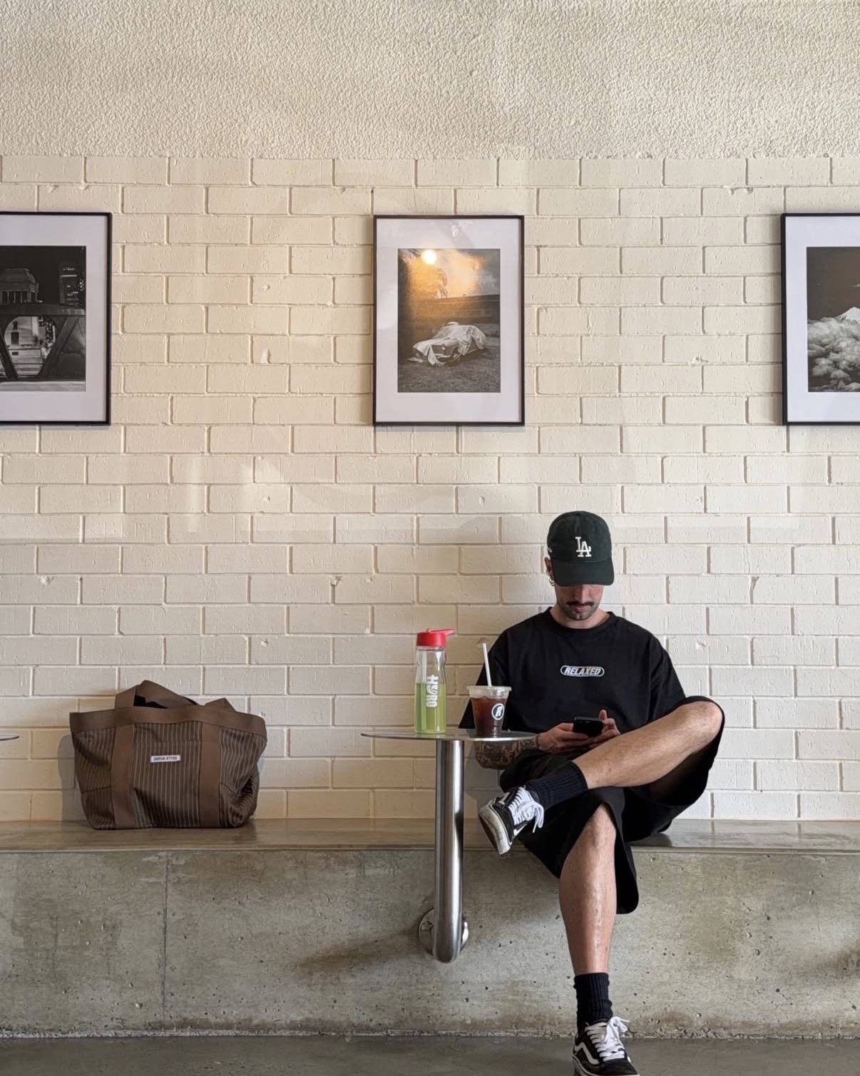 A local relaxing with a coffee on the concrete bench under the film prints